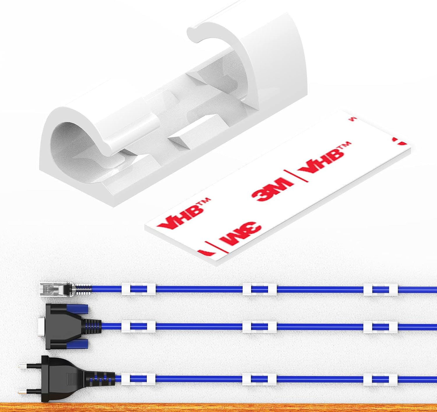 Set of white adhesive cable clips routing charging cables along a desk