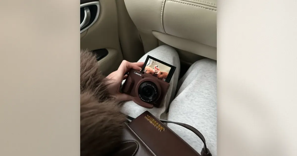 Canon G7 X Mark III Kompaktkamera in Braun in der Hand mit aufklappbarem Bildschirm