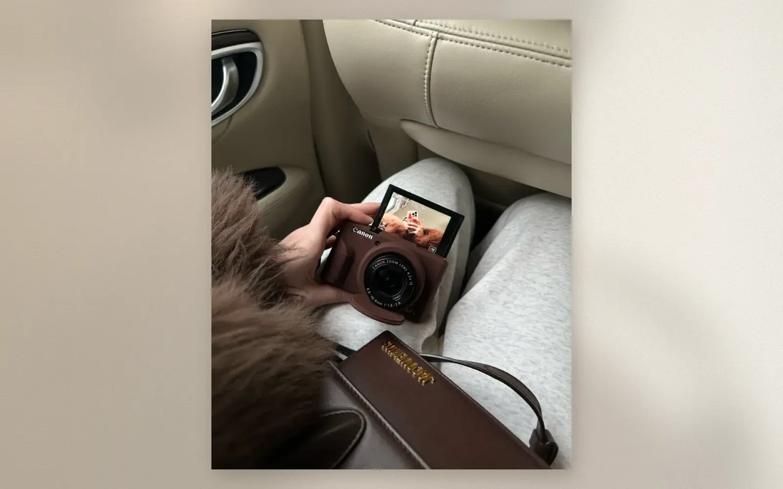 Canon G7 X Mark III compact camera in brown held in hand with flip-up screen showing a dog photo