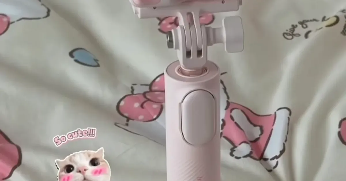 Insta360 GO Ultra Hello Kitty Kamera auf dem rosa Griff mit ausgeklappten Stativbeinen
