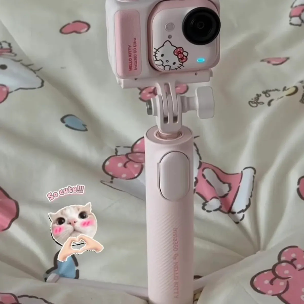Insta360 GO Ultra Hello Kitty camera mounted on the pink grip handle with fold-out tripod legs