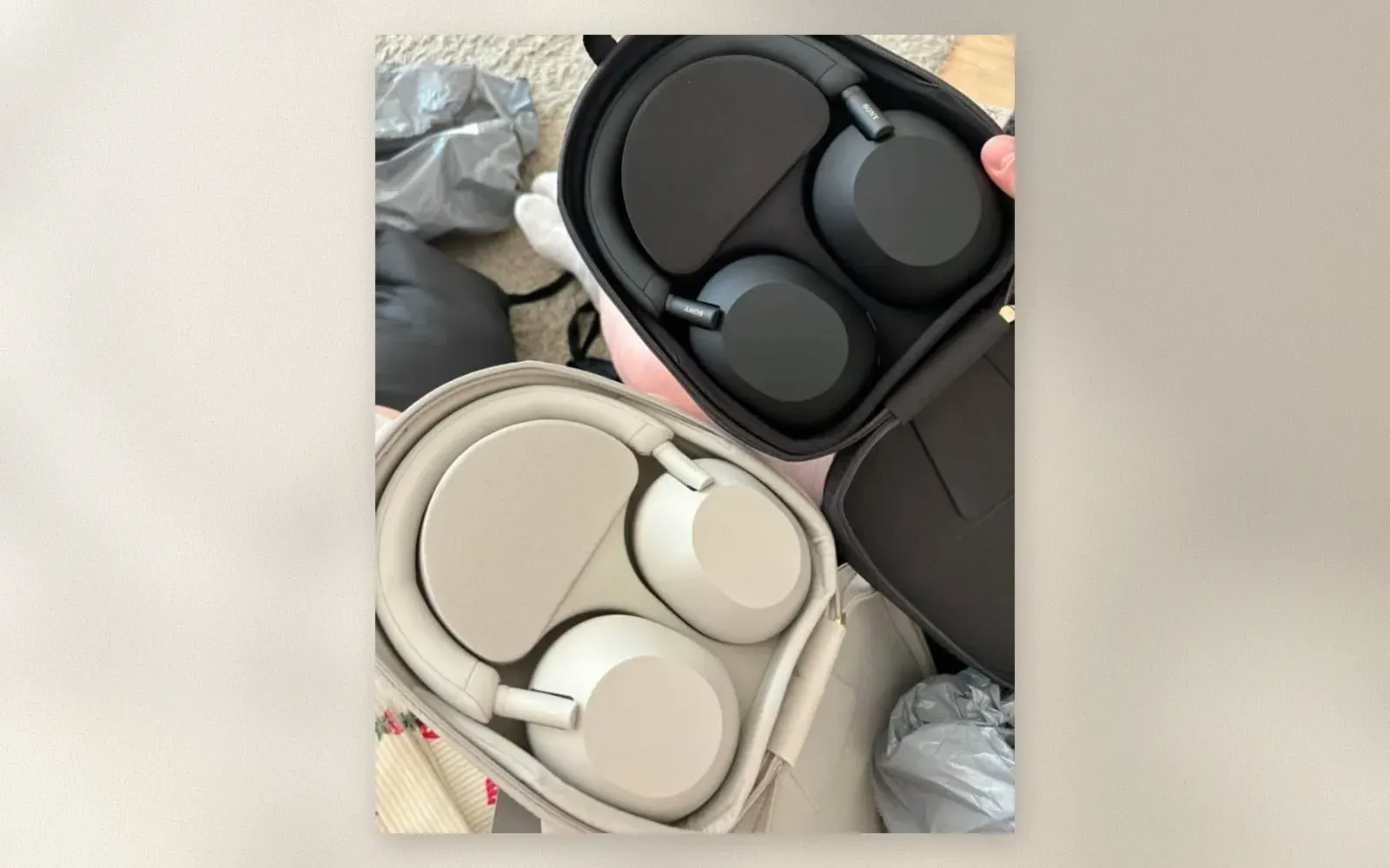 Sony WH-1000XM6 in black and WH-1000XM5 in silver lying in their carrying cases