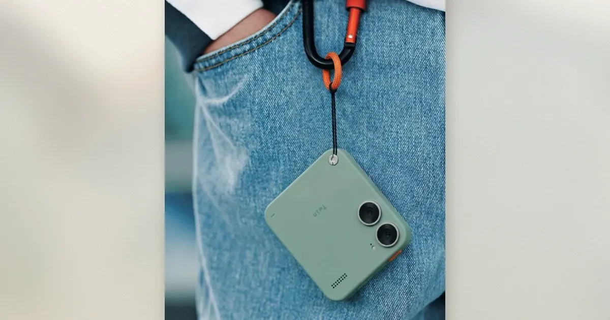 Kleine salbei-grüne Dual-Lens Mini-Kamera am Karabiner über Jeans hängend
