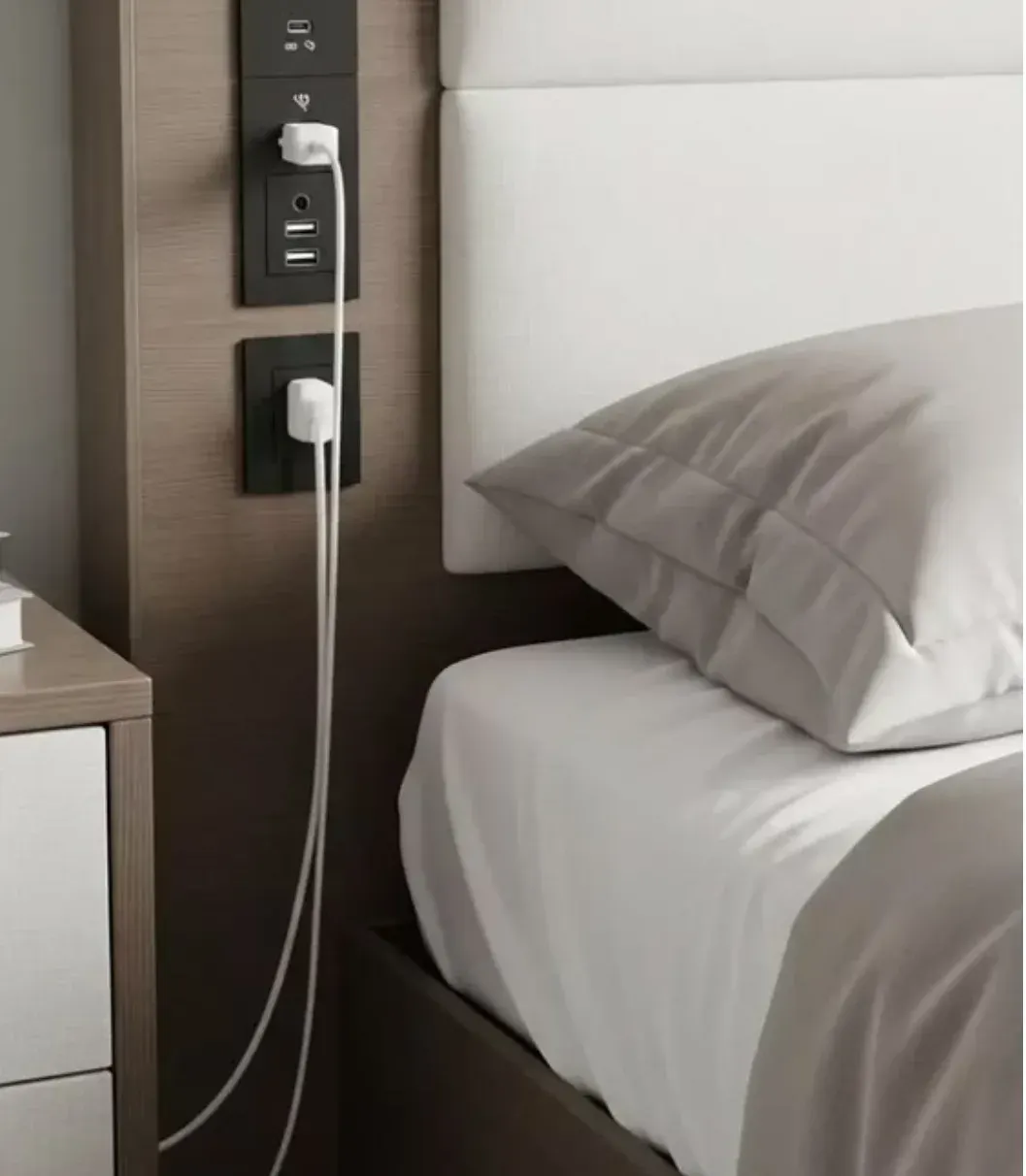 Bedside charging niche: black hidden charging panel with outlets and USB ports built into a wooden headboard wall