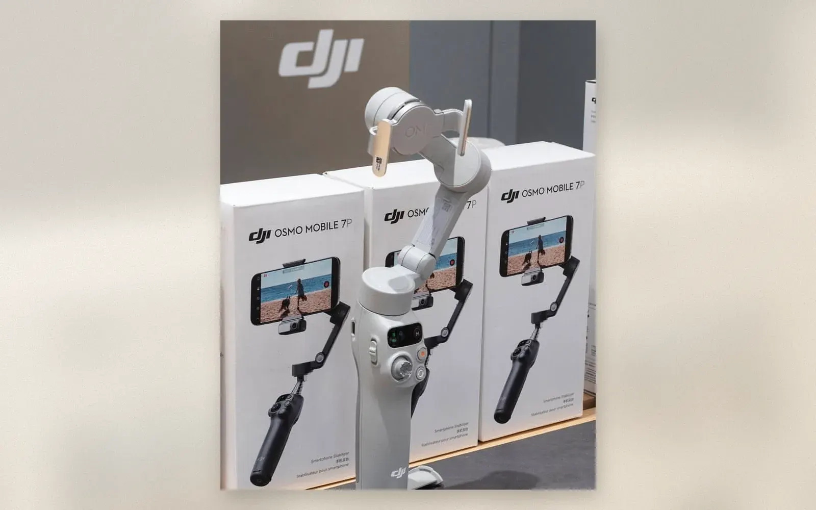 DJI Osmo Mobile 7P smartphone gimbal in gray on a display stand in front of retail boxes