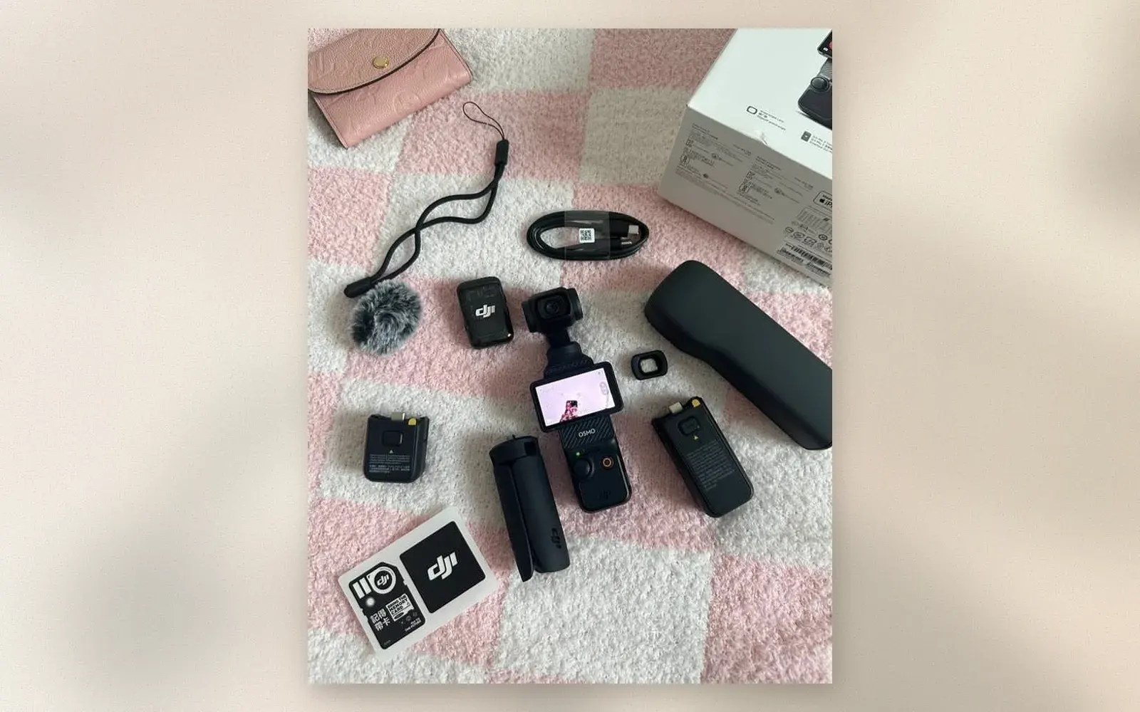 DJI Osmo Pocket 3 Creator Combo laid out with battery handle, batteries, and DJI Mic 2 transmitter