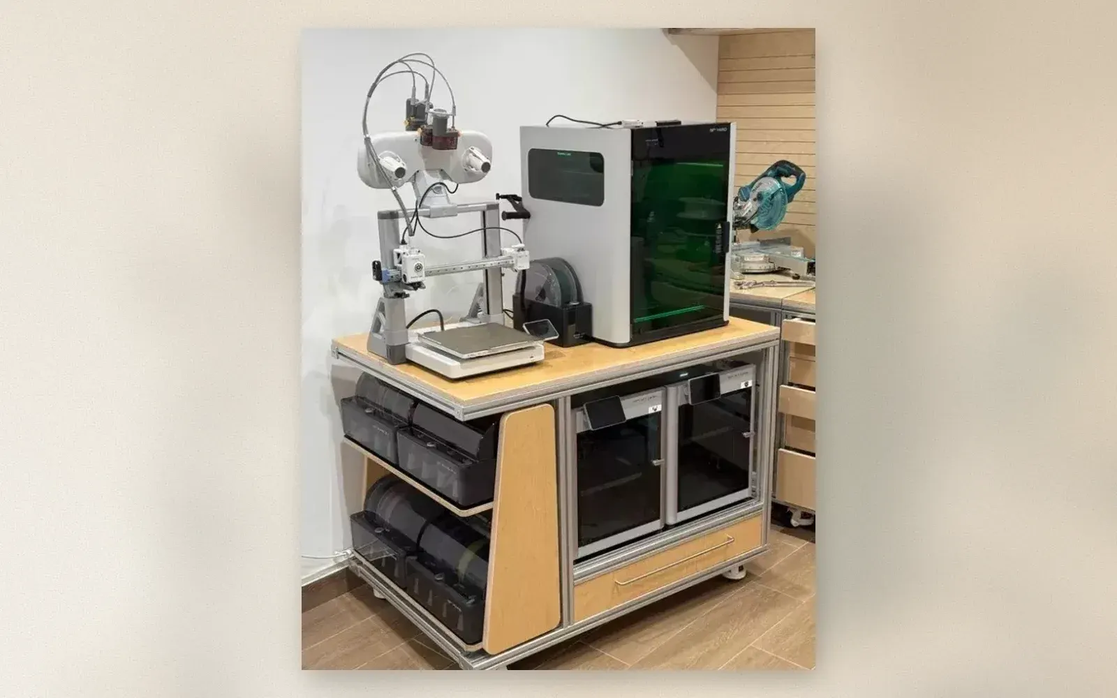 3D printer workstation cart with two printers, filament dry boxes, and storage bins on locking casters