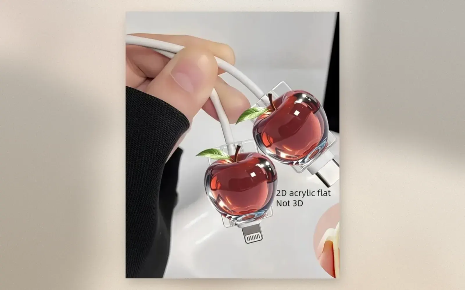 Red apple shaped acrylic cable protector charm on a Lightning and a USB-C charging cable