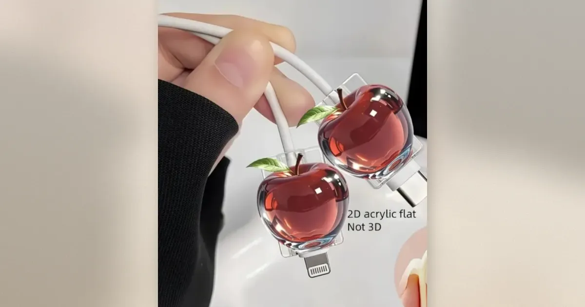 Roter Apfel aus Acryl als Kabelschutz an einem Lightning- und einem USB-C-Ladekabel