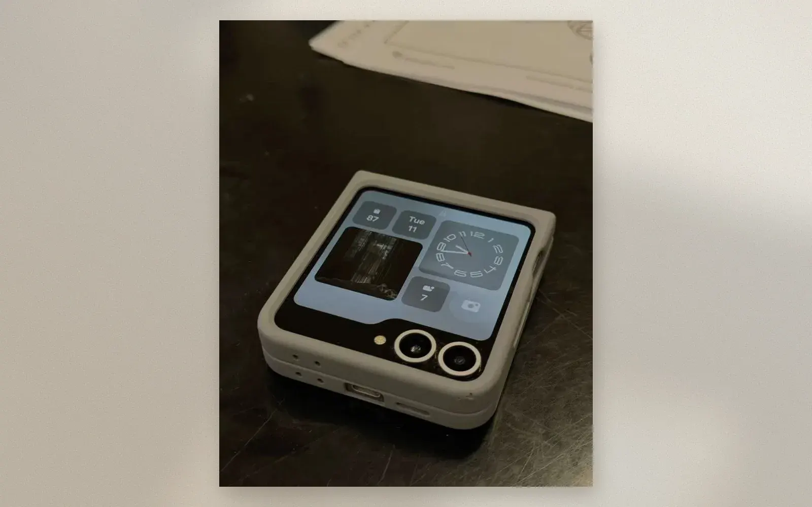 Samsung Galaxy Z Flip 7 half-folded in Flex Mode showing the cover screen widgets