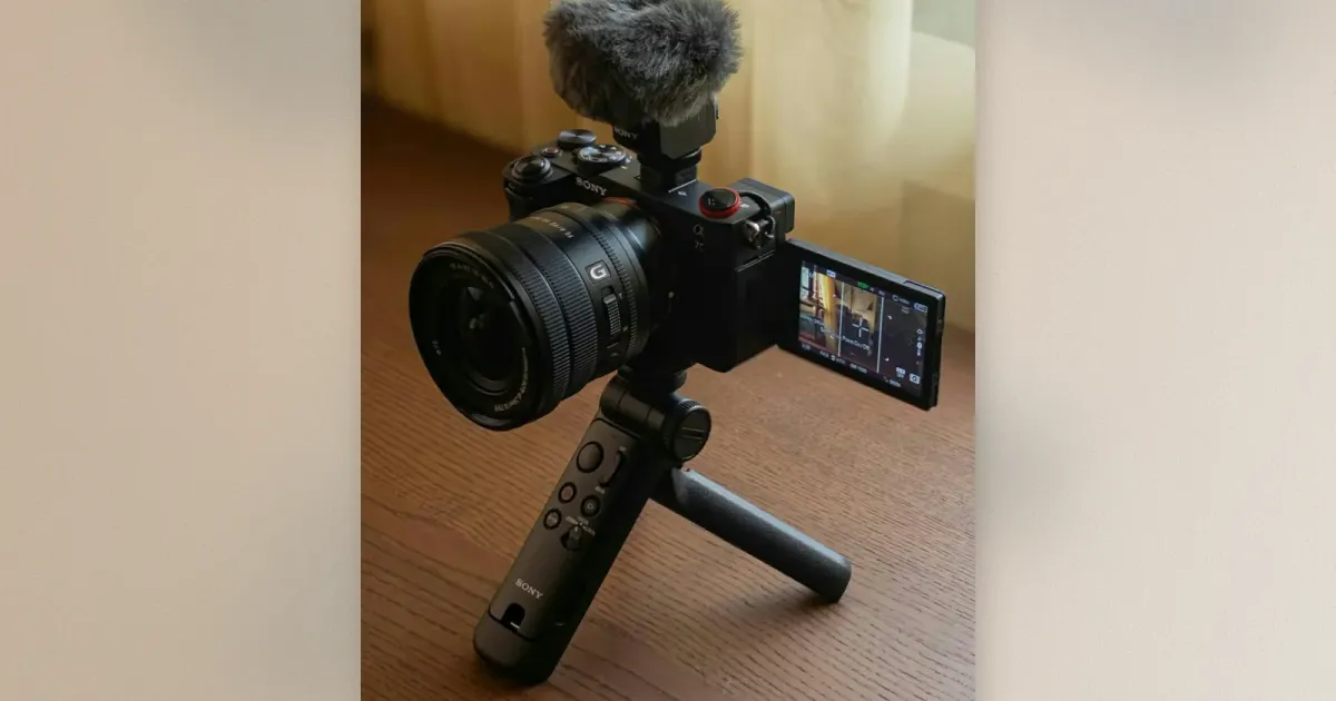 Sony A7C mit Power-Zoom-Objektiv, Shotgun-Mikrofon und GP-VPT2BT Grip auf Holztisch