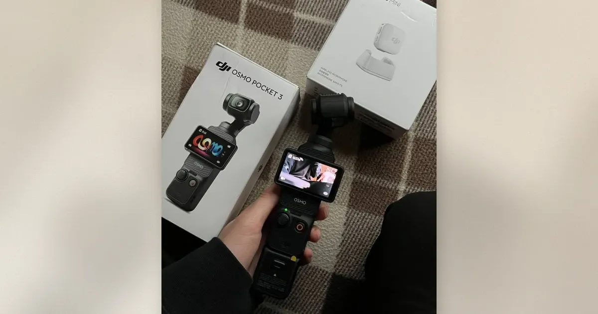 Hand hält die DJI Osmo Pocket 3 vor ihrer Retail-Box und einer DJI Mic Mini Verpackung