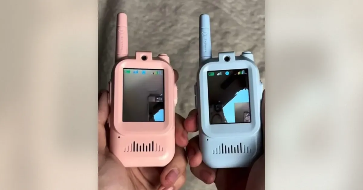 Zwei pastellfarbene Mini Walkie-Talkies mit Kamera-Display, rosa und blau, in Händen gehalten