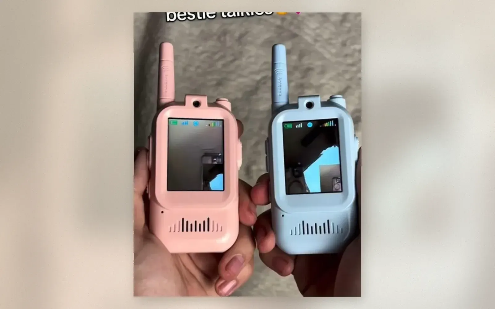 Two pastel mini walkie-talkies with camera screens, one pink and one blue, held in hands