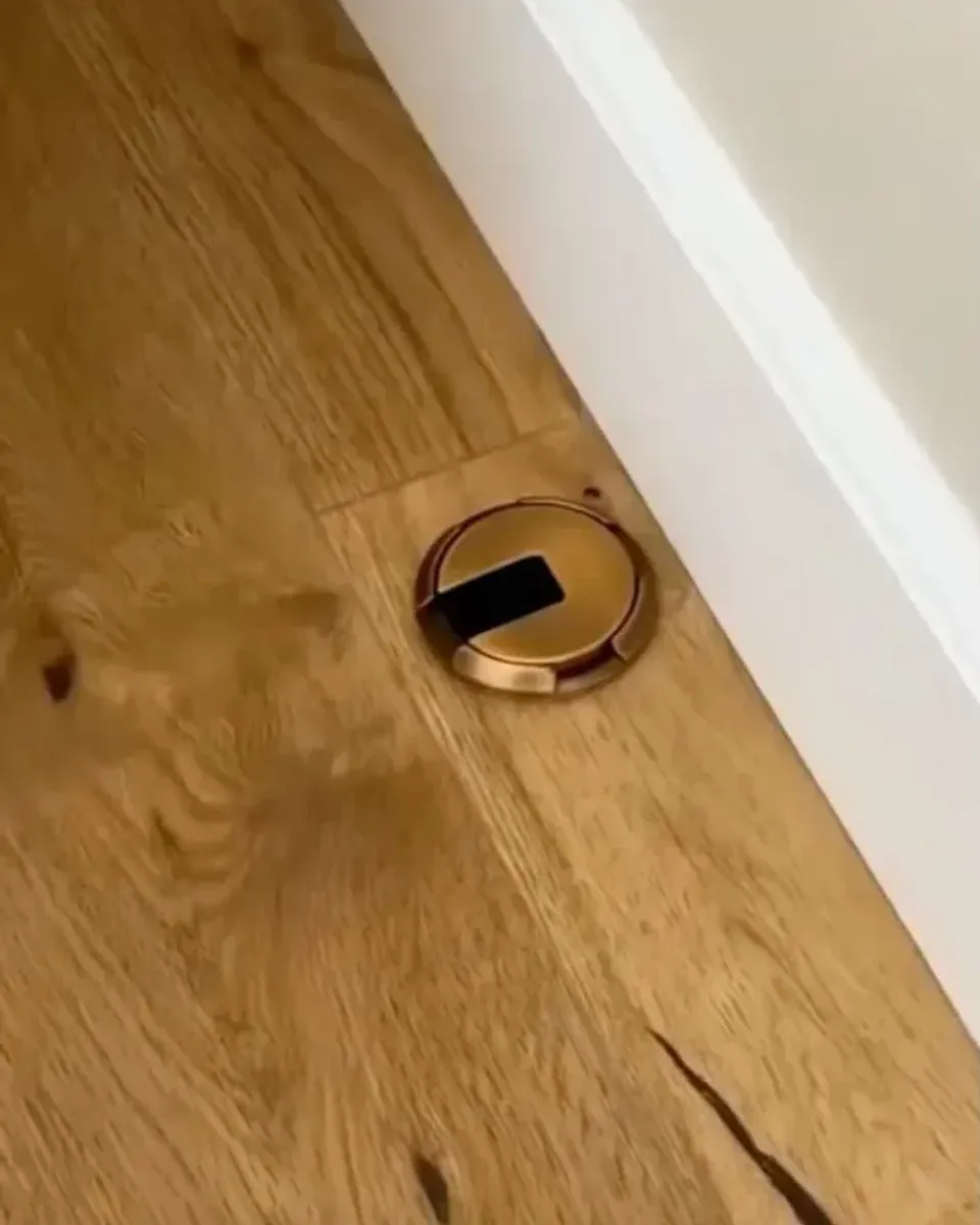 Close-up of the recessed outlet showing the flip lid mechanism and brass finish