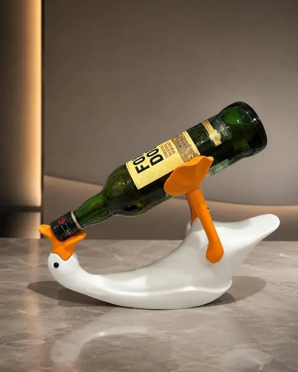 Close-up of the duck’s beak supporting the wine bottle