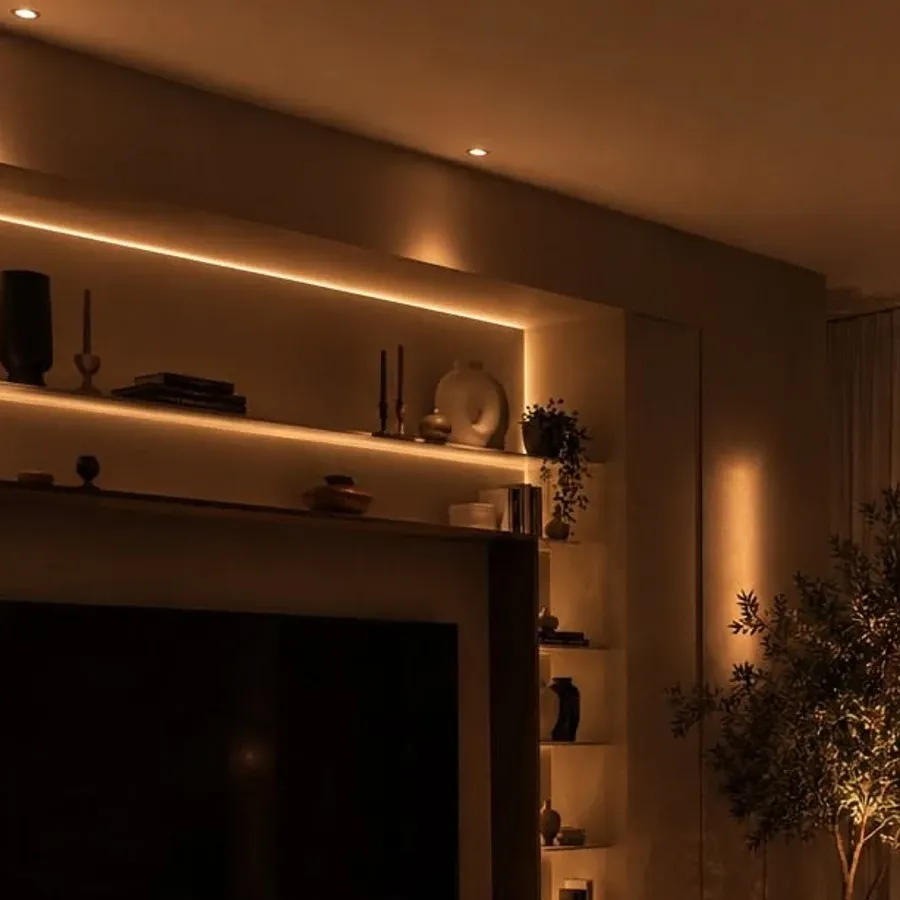 Warm LED strip glow washing over the wall shelves of a minimalist living room