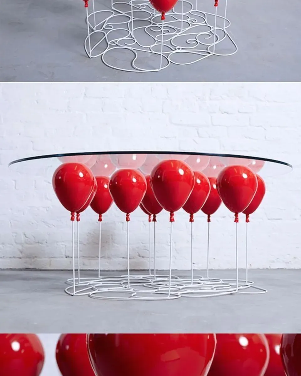 Whimsical balloon table with red balloon-shaped legs supporting a glass tabletop