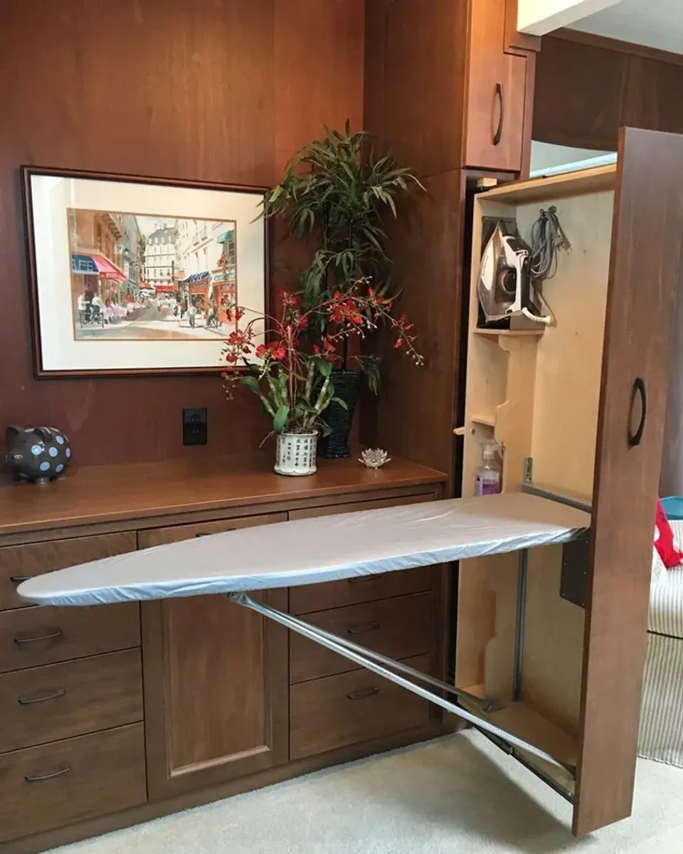 Built-in ironing board cabinet closed showing the wooden door panel