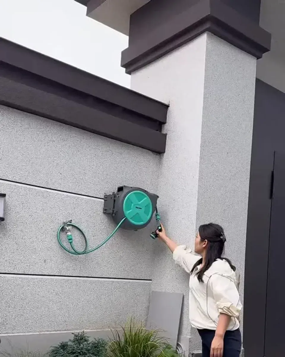 Close-up of the hose retracting into the wall-mounted box