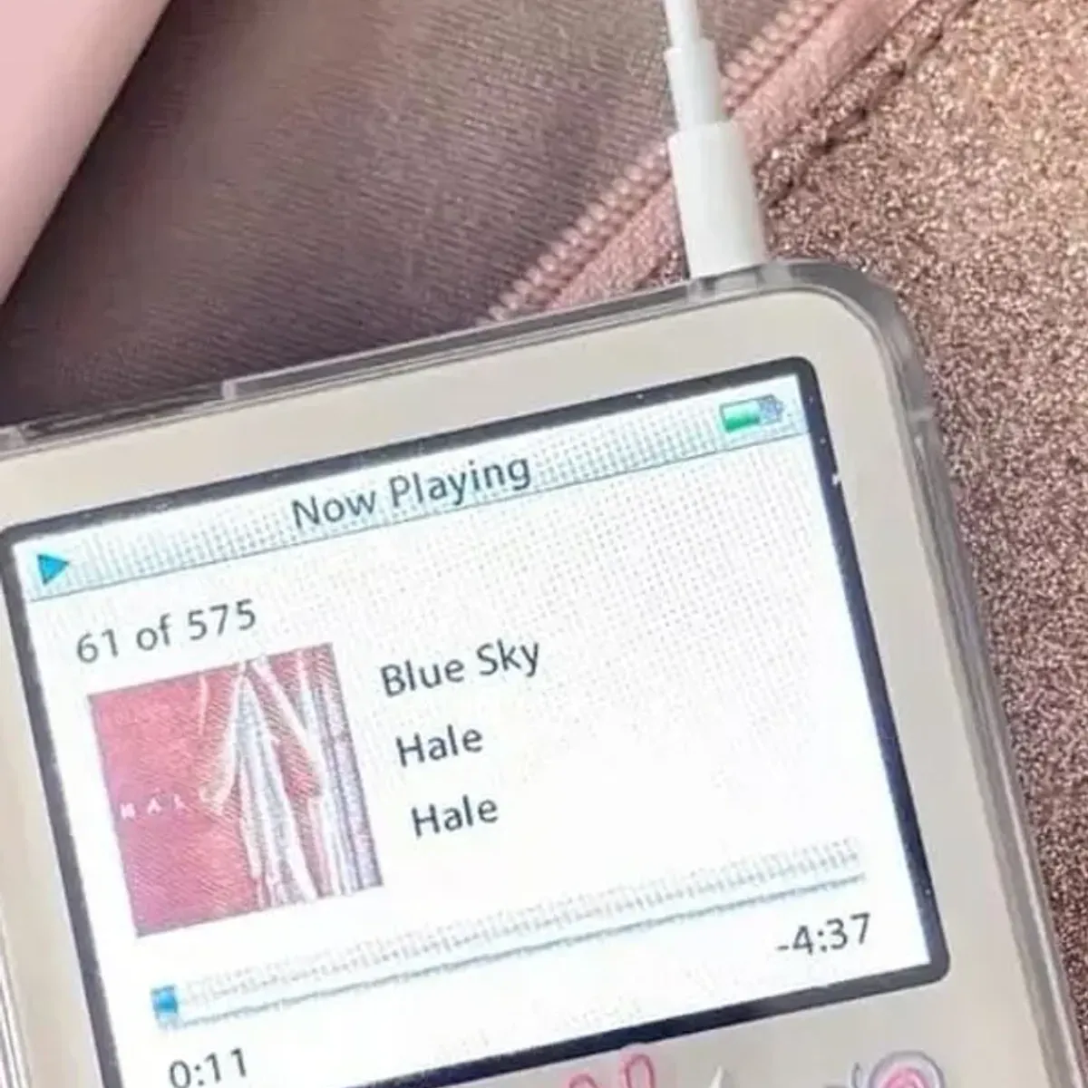 iPod-Classics-Bildschirm mit der Now-Playing-Oberfläche und der sichtbaren Case-Kante