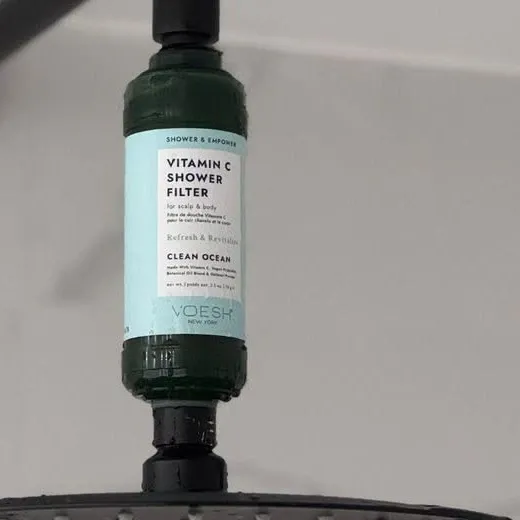 Flash of water running through the mounted VOESH cartridge under a rain shower head