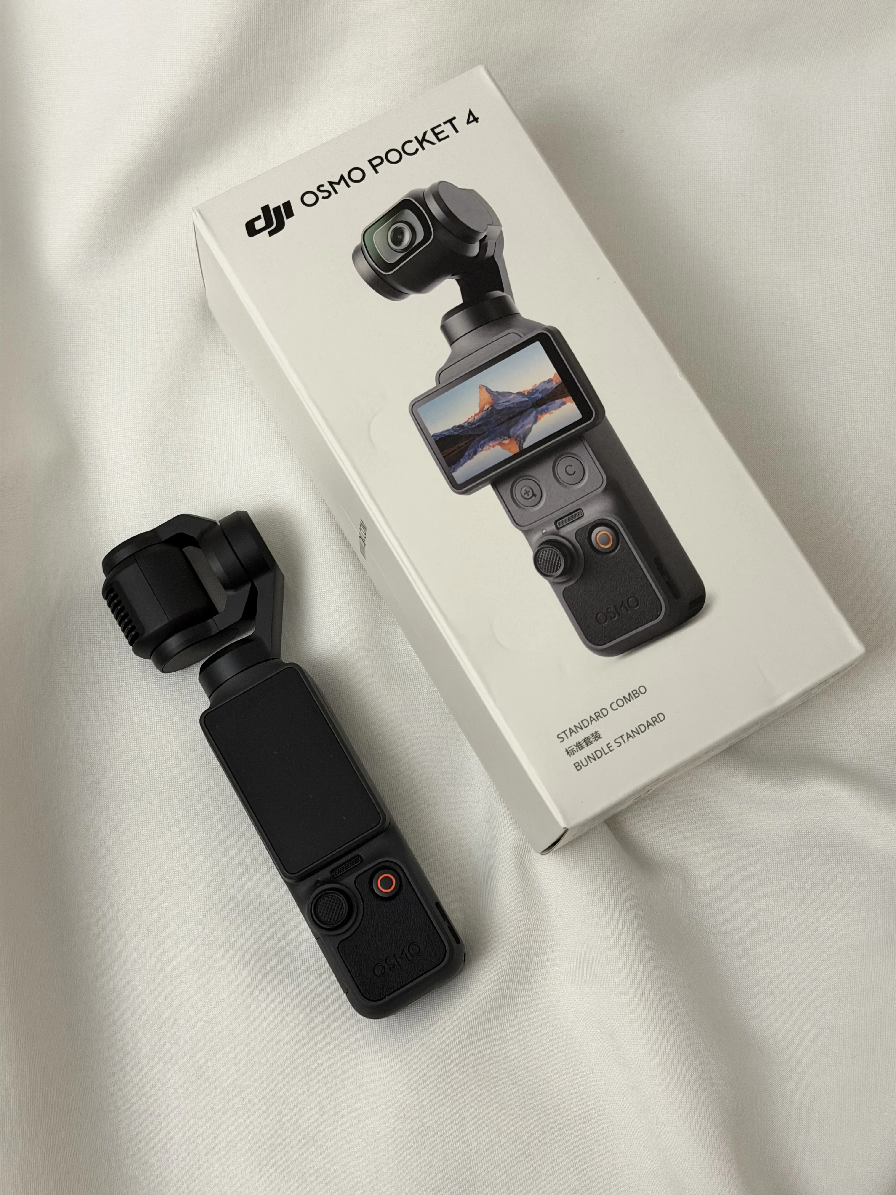 DJI Osmo Pocket 4 gimbal camera beside its Standard Combo retail box
