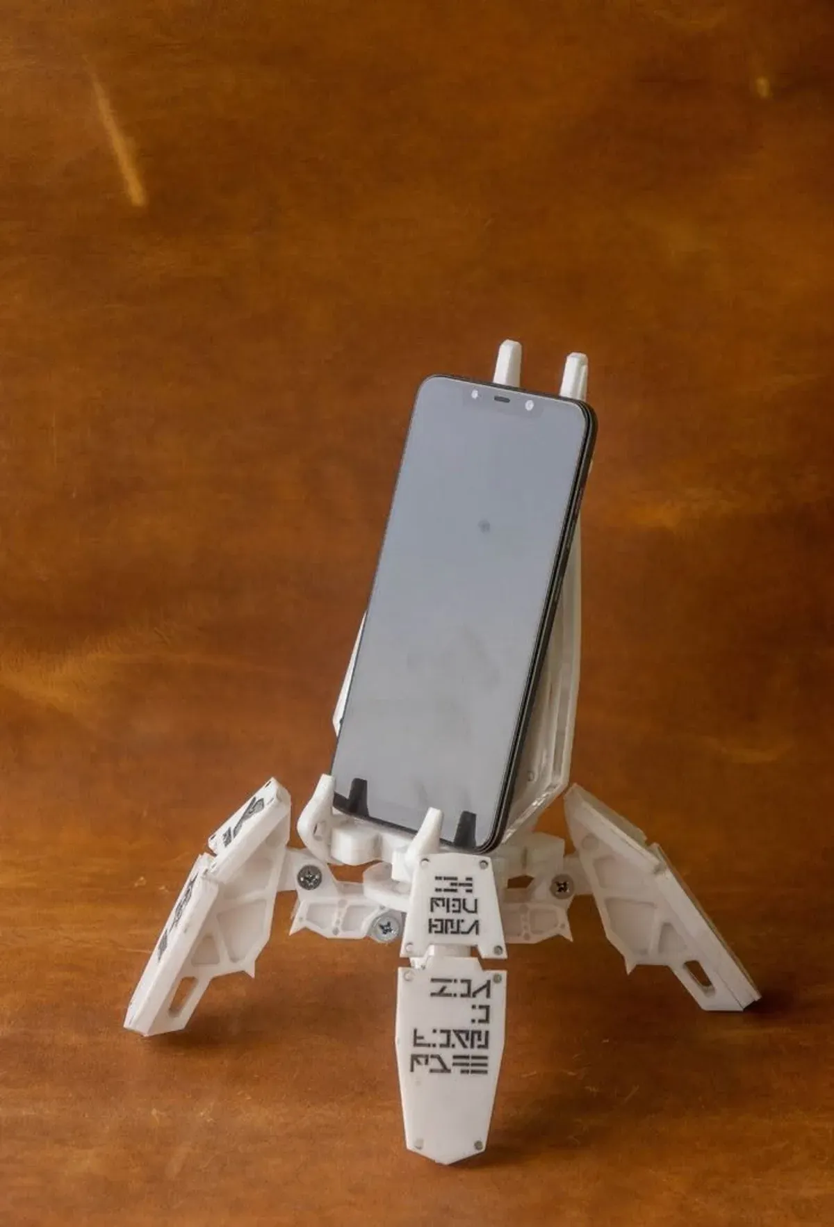 Mech-Exo-Suit-Handyhalterung, die ein Smartphone von vorne greift