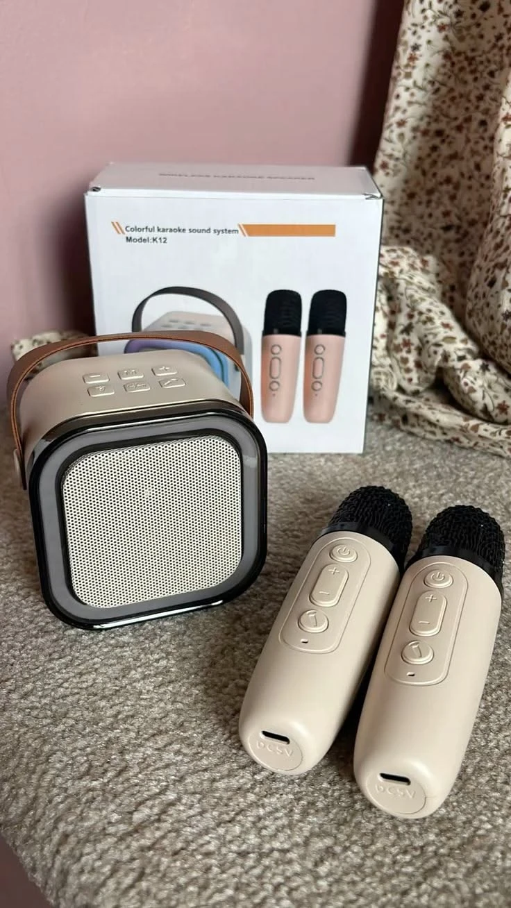 The K12 karaoke sound system with two wireless microphones next to its box
