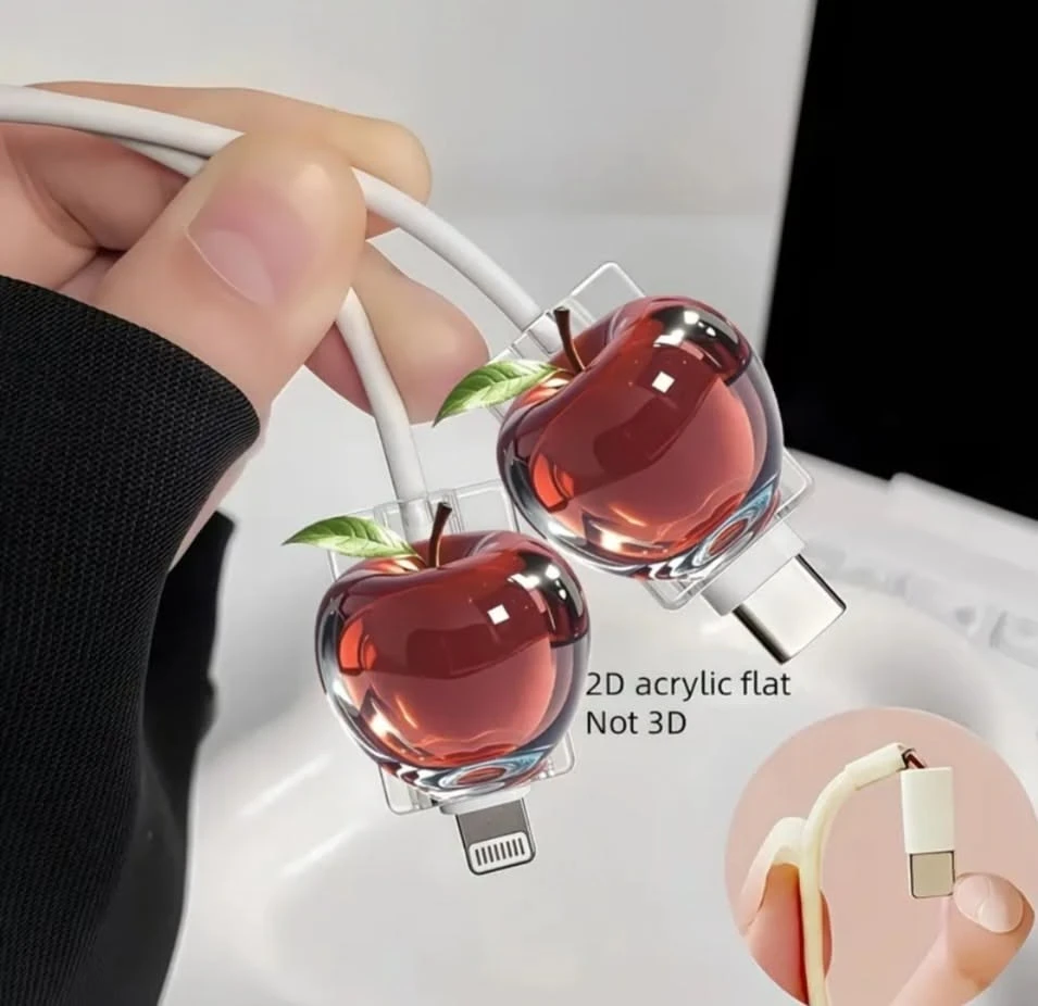 Two cable protector charms fitted on a Lightning and a USB-C charging cable, held in a hand
