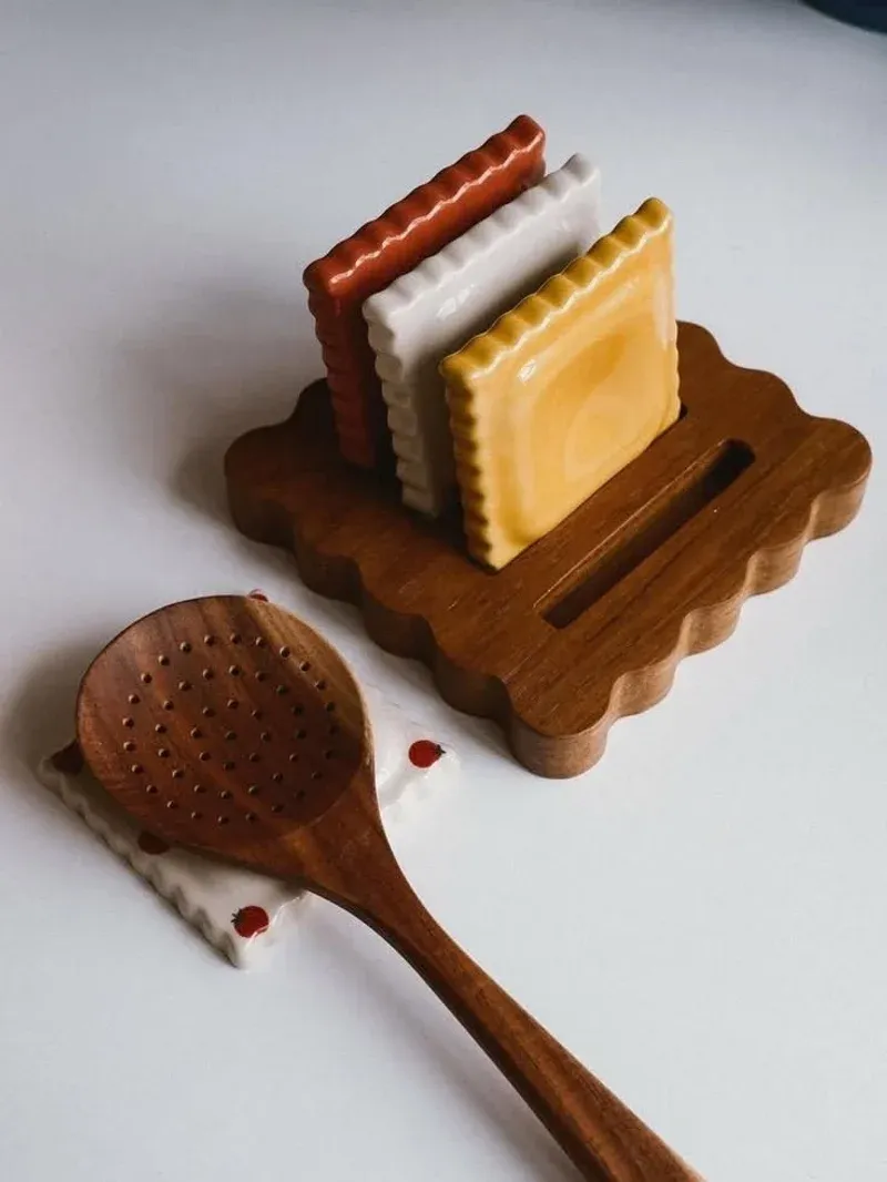 Ceramic biscuit spoon rest tiles in the wooden holder showing the three colors