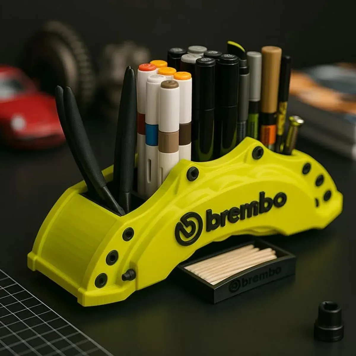 Brembo-Bremszangen-Stifthalter in Limettengrün mit schwarzen Akzenten auf dunklem Schreibtisch