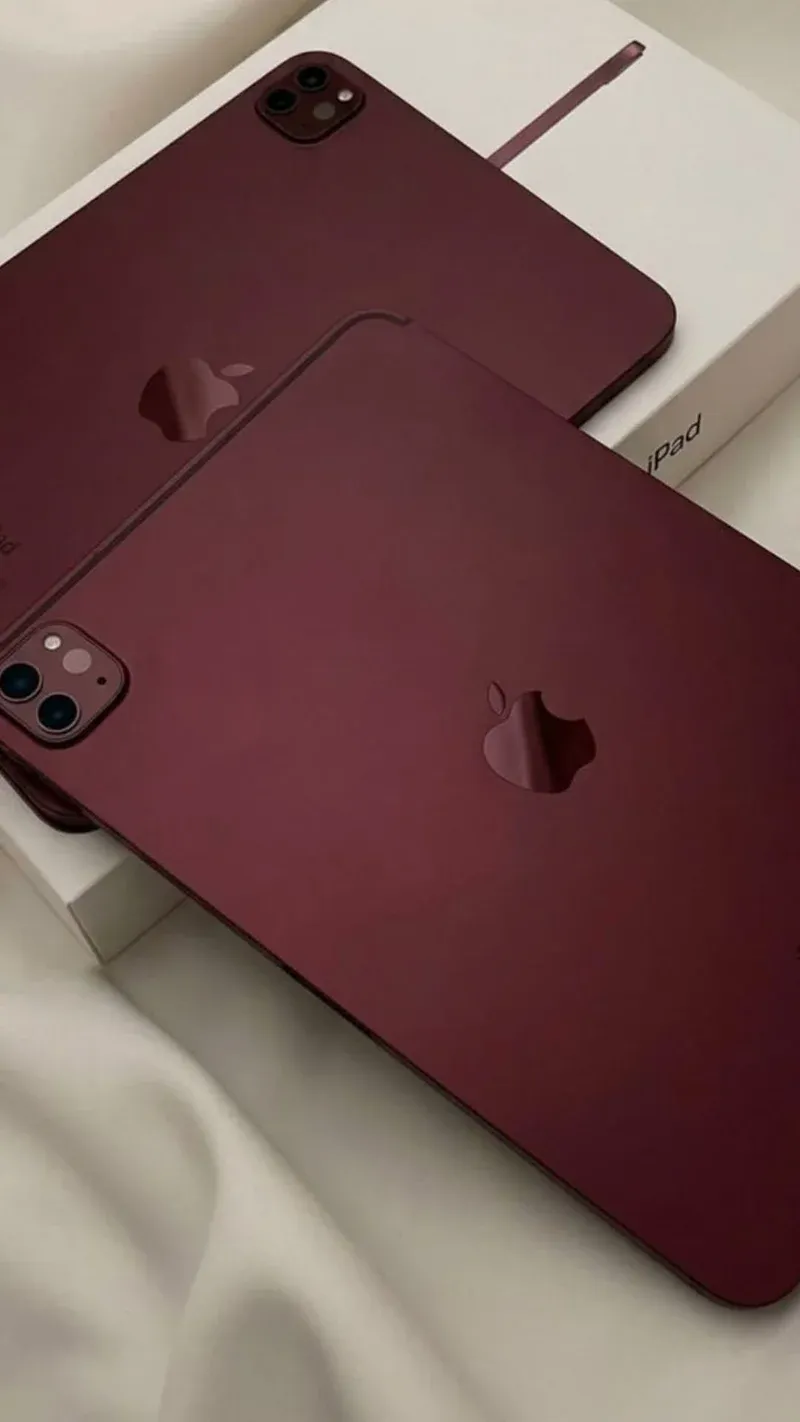 Two burgundy-wrapped iPad Pros showing the vinyl finish and camera cutouts