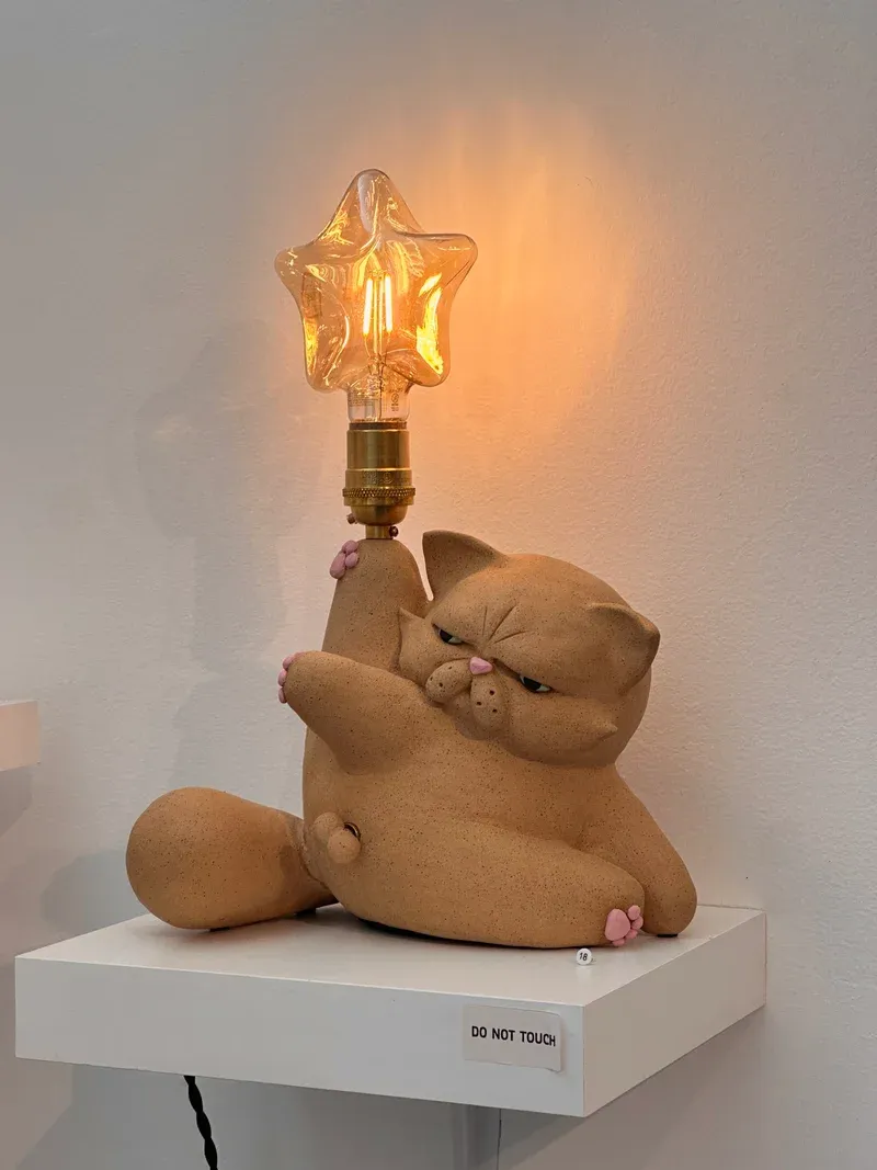 Ceramic cat lamp showing the grumpy expression and star-shaped bulb