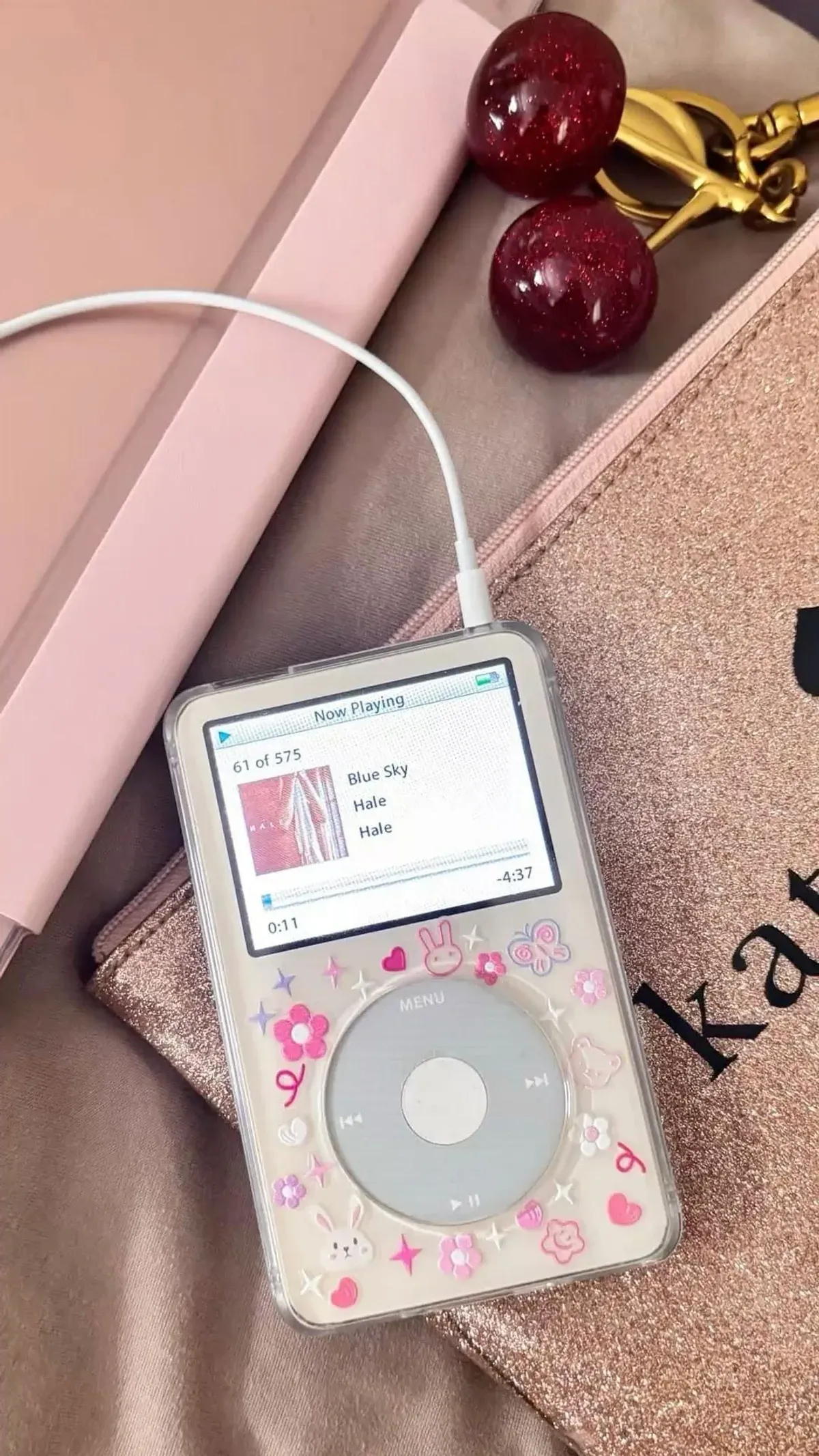 Weißer refurbished iPod Classic im transparenten Case mit Kawaii-Stickern auf einem rosa Notizbuch