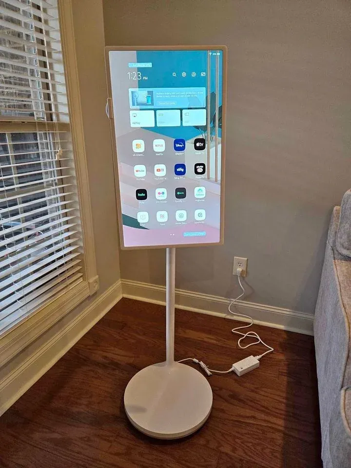 Smart TV turned vertically on its floor stand in a living room corner