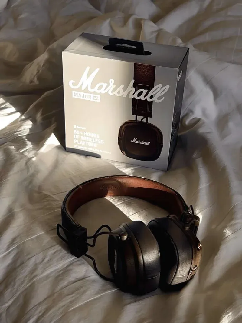 Marshall Major IV Kopfhörer und Box auf weißer Bettwäsche