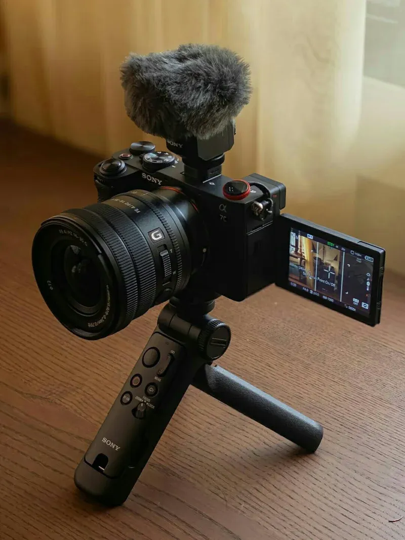 Sony A7C with power zoom lens, shotgun mic, and grip tripod