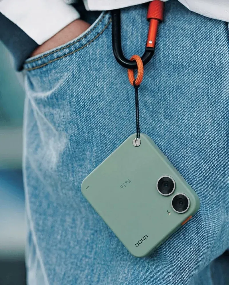 Dual-lens mini camera hanging from carabiner on jeans