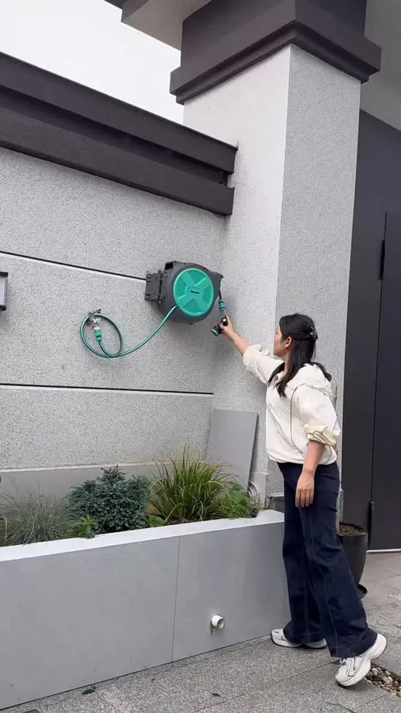 Retractable garden hose reel showing the wall-mounted box and extended hose